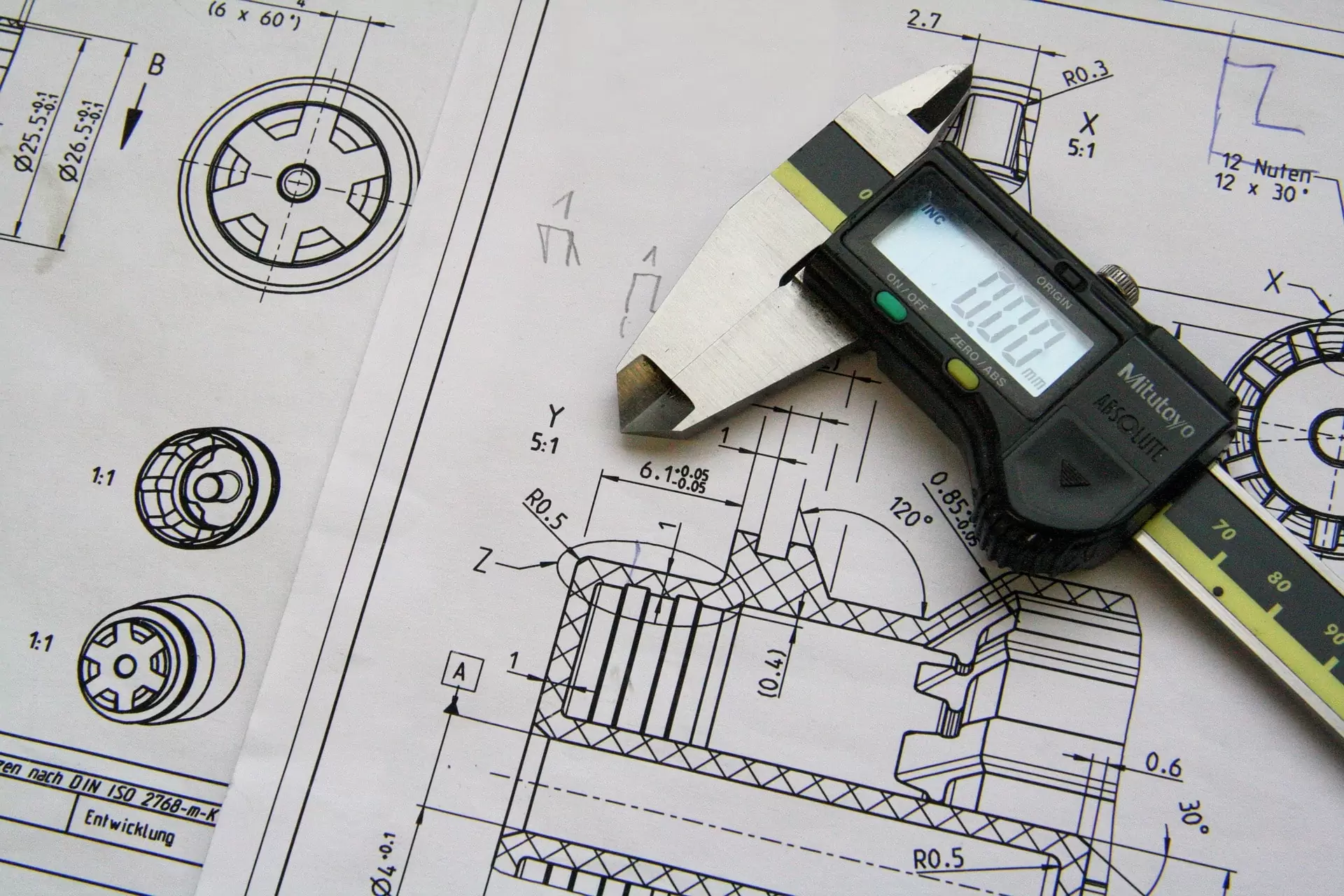 Desenhista técnico trabalhando com paquímetro e desenho técnico
